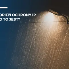 Latarnia uliczna w deszczu, oświetlająca krople wody. Tekst: "Stopień ochrony IP - co to jest?".