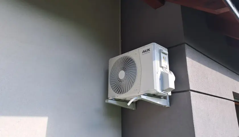 Zastanawiasz się, jaka klimatyzacja do domu będzie najlepsza? Zobacz, jak wygląda jednostka zewnętrzna klimatyzatora AUX DC INVERTER zamontowana na ścianie budynku.